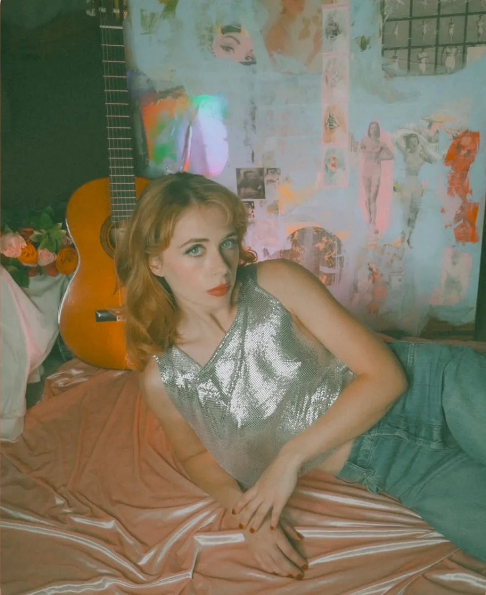 Miss Autumn poses beside a guitar in a collage-style electronic press kit.